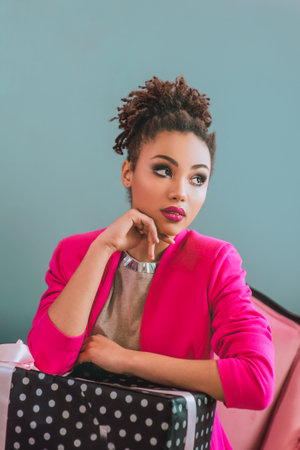 Unhappy and cheerful afro american woman with present box on the christmas tree background. Christmas, new year, happiness, holidays conceptの写真素材