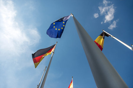 Flags of the European Union, Germany, and Belgium waving in the wind.の写真素材