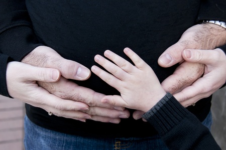 Families hands on pregnant bellyの写真素材
