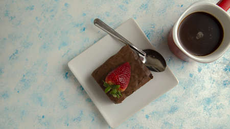 brownie with strawberry on plate on textured backgroundの写真素材