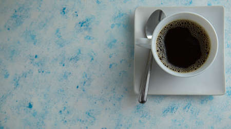 cup of coffee accompanied by plate on textured backgroundの写真素材