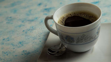 cup of coffee accompanied by plate on textured backgroundの写真素材