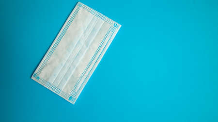 biosafety element white mask accompanied by technological objects on a unicolor background