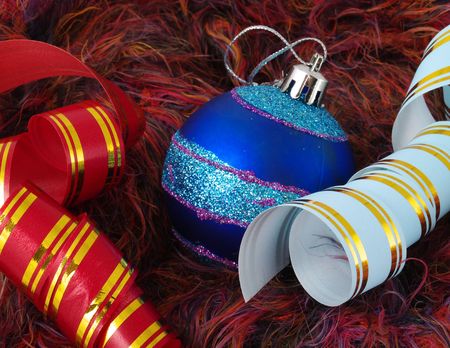 Christmas blue ball and color ribbons on a fluffy backgroundの写真素材