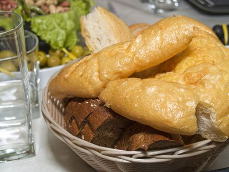 Pieces of different sort of bread and Italian chiabatta in biscuit dish on the served tableの写真素材