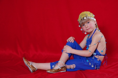 Little girl in oriental costume on a red backgroundの写真素材