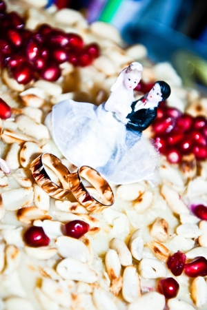 Figurine on a wedding cake next to the wedding ringsの写真素材
