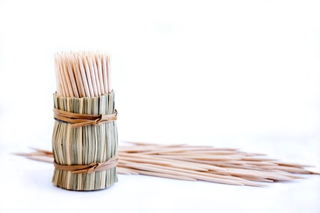 Bunch of wooden toothpick in round wattled straw holderの写真素材