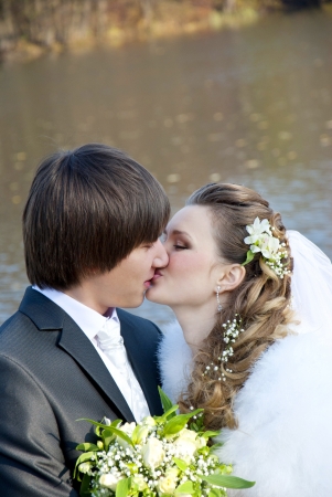 Bride and groom on the background of the autumn forest and riverの写真素材
