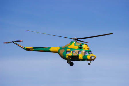 Military helicopter flying in the blue sky