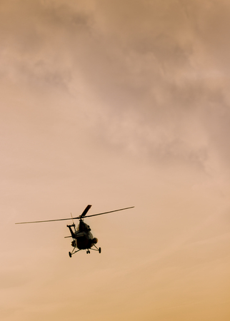 The patrol helicopter flying in the sunset skyの写真素材