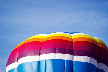 Colorful hot air balloon moving up in the blue sky.の写真素材