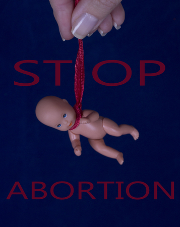 Hanging in the loop of an embryo in a woman's hands. Concept of protection of life and abortion の写真素材