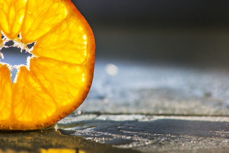 tangerine slice on wooden background back lightedの写真素材