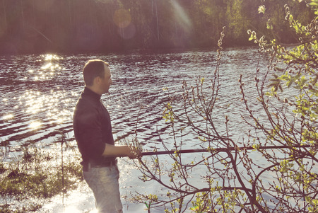 fisherman fishing in a river outdoors with spinningの写真素材
