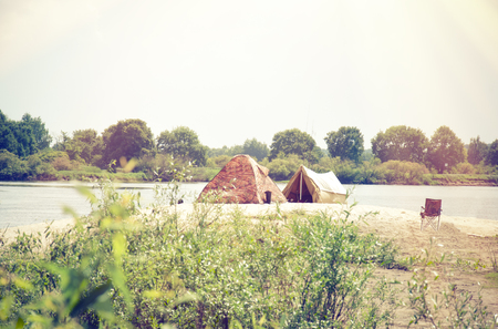Camping tent near the river in the summer.の写真素材