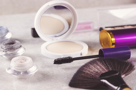 Makeup cosmetics and brushes on light textured background.の写真素材
