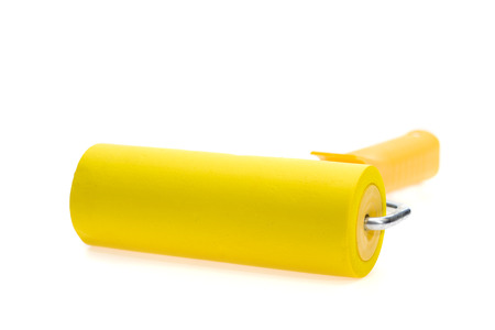 Yellow paint roller, isolated on white background. With shadow