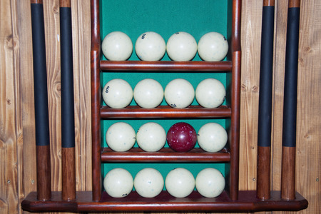 Billiard balls lie on the shelves, cue storage and a set of billiardsの写真素材