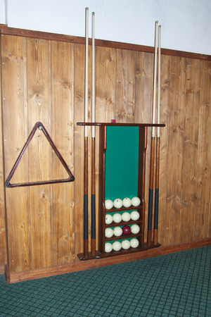 Billiard balls lie on the shelves, cue storage and a set of billiards