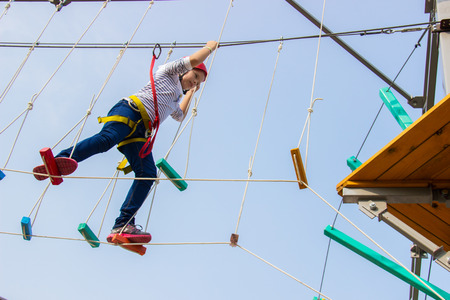 Little girl climbing on an outdoor ropes courseの写真素材