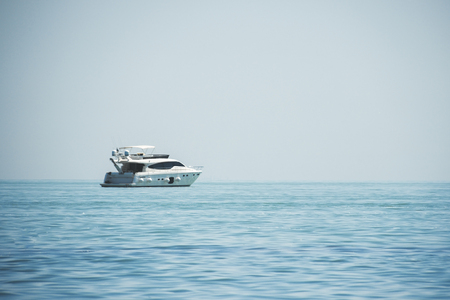 White yacht in the blue sea against a clear blue sky background.の写真素材