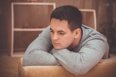 Handsome depressed man at home, closeupの写真素材