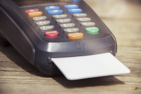 POS payment terminal on wooden background.の写真素材
