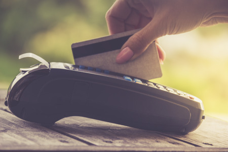 Woman using bank terminal for credit card payment.