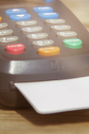 POS payment terminal on wooden background. Credit card terminal, EFTPOS terminalの写真素材