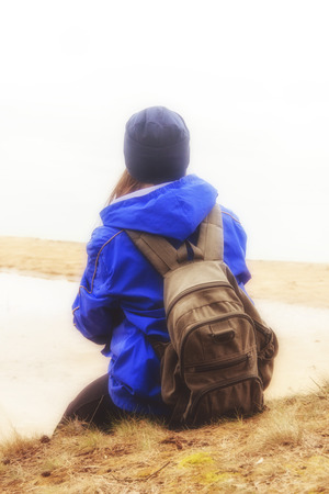 Woman with backpack traveling hiking. Lifestyle adventure concept forest and lake on background active vacations into the wild.の写真素材