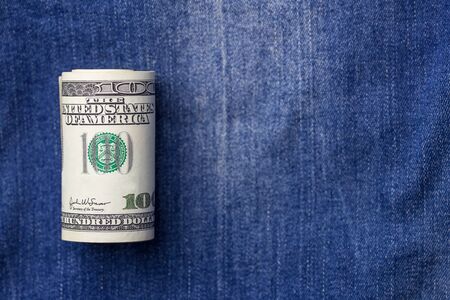 Roll of dollars on denim, symbol of America USA with copy spaceの写真素材