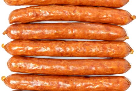Background of dry sausages. Kabanos sausages folded in a row close-up on a white background.の写真素材