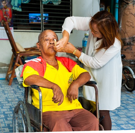 BANGKOK THAILAND - JUNE 3, 2016 : Woman barber haircut to The Old man in Bangkok Thailand.のeditorial素材