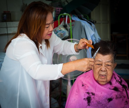 BANGKOK THAILAND - JUNE 3, 2016 : Woman barber haircut to The Old woman in Bangkok Thailand.のeditorial素材