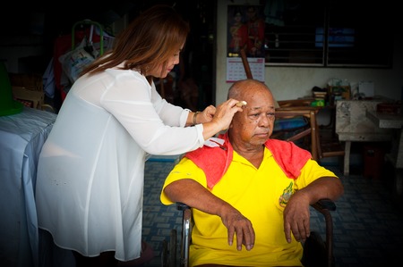 BANGKOK THAILAND - JUNE 3, 2016 : Woman barber haircut to The Old man in Bangkok Thailand.のeditorial素材