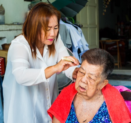 BANGKOK THAILAND - JUNE 3, 2016 : Woman barber haircut to The Old woman in Bangkok Thailand.のeditorial素材