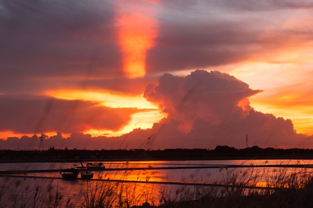 Colorful light Sunset while cloudy at salt field.の写真素材