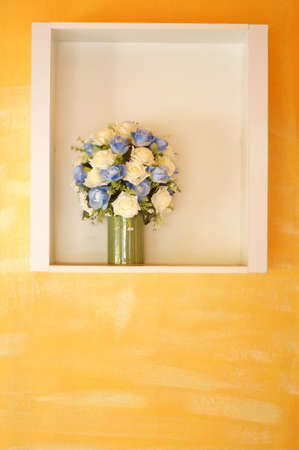 Artificial flowers on yellow Wallの写真素材