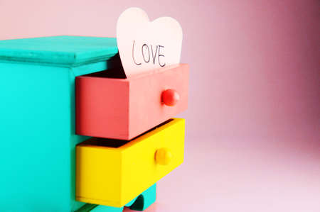 Wording, Love. On pink heart paper note in drawer vintage wood box.