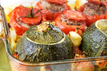 Transparent plate with cooked tomatoes and marrows stuffed with minced meat with sauce.の写真素材