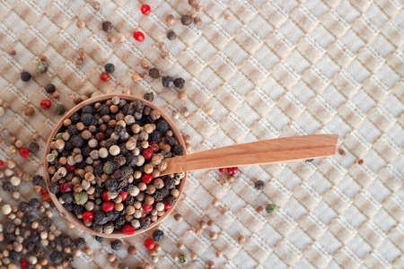 A wood bowl of mixed pepper and red dry berries on brown background.の写真素材