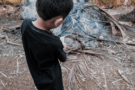 kids help burn the dead grassの写真素材