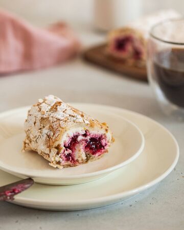 Dessert pistachio roll with raspberry filling on a saucer with a cup of coffee. Food photo with...