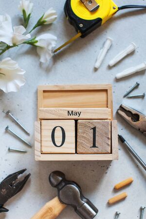 Flatlay with building materials, white flower and May 1 date. Concept Day of international solidarity of workers, labor day.の写真素材