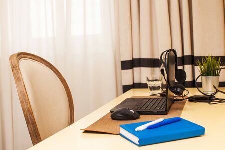 Workspace at home laptop, headphones, work notebook. The concept of remote work, home office, work during a pandemic. Horizontal photo with place for text.の写真素材