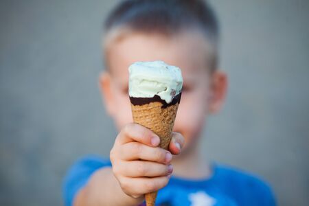 Ice cream horn close-up in a childâs handの写真素材
