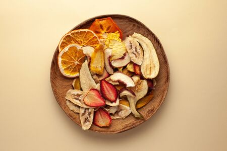  Dried fruit chips on a wooden plate. The concept of a healthy snack without sugar, dessert for...