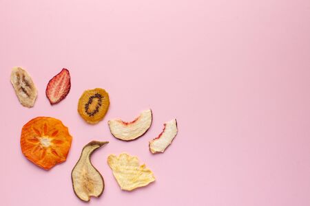  Dried fruit chips on a pink background. The concept of a healthy snack without sugar, dessert for vegetarians. Copy space. Flatlayの写真素材