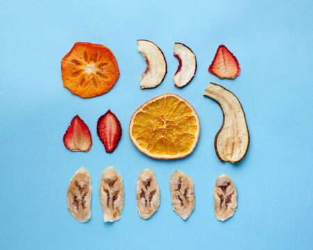  Dried fruit chips of banana, orange and others on a blue background. Sugar free healthy snack concept, dessert for vegetarians. Flatlayの写真素材